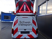 Rückansicht eines Schwertransportfahrzeugs mit Warnschild