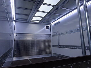 Leerer LKW-Innenraum mit Metallwänden und Decke.