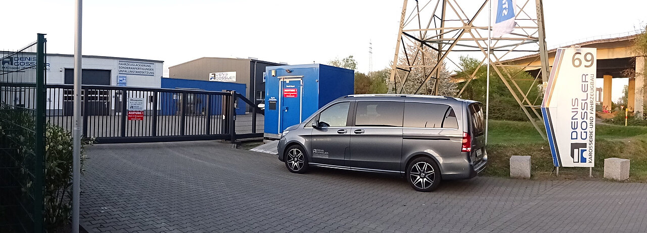 Eingang der Denis Gossler Autowerkstatt mit geparktem Van.
