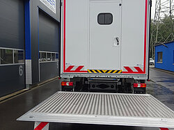 LKW mit geöffneter Ladebordwand vor Werkstatt