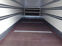 Innenansicht eines leeren LKW-Aufbaus mit Holzfußboden.