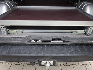 Offene Stauraum-Schublade im Fahrzeugkofferraum.
