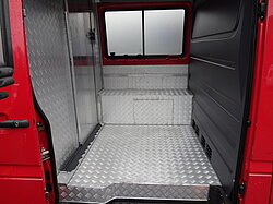 Leerer Innenraum eines roten Transporters mit Metallboden.