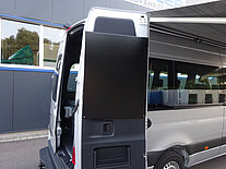 Ein Transporter mit geöffneter Hecktür, vor einem Gebäude geparkt.