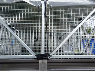 Nahaufnahme eines LKWs mit Metallgitter und Planenabdeckung.