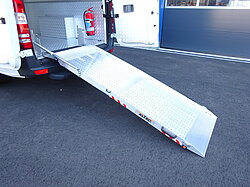 Transporter mit ausgefahrener Metallrampe.