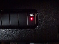 Nahaufnahme eines Differentialsperrknopfs im Auto mit rotem Licht.