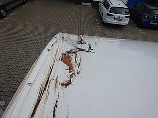 Nahaufnahme eines Fahrzeugdachs mit sichtbaren Schäden und Kratzern.