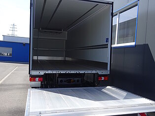 Offener LKW-Laderaum mit ausgefahrener Rampe.