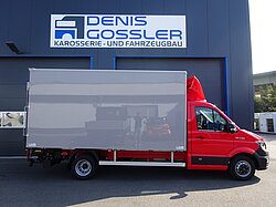 Roter LKW vor Werkstattgebäude.