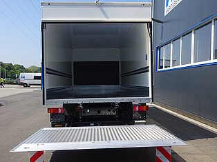 Offener LKW mit ausgefahrener Laderampe.