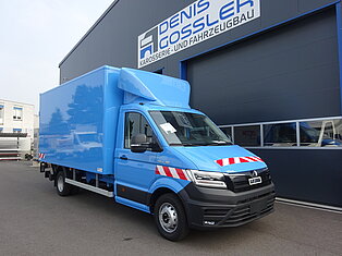 Blauer Lieferwagen vor einem Gebäude geparkt.