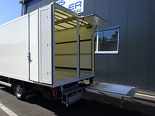Offener Lieferwagen mit ausgefahrener Rampe.
