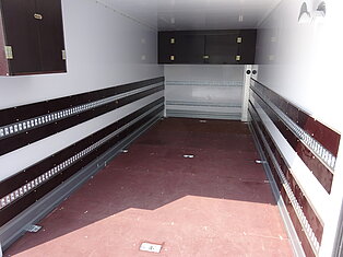 Innenansicht eines leeren Anhängers mit Holzverkleidung.