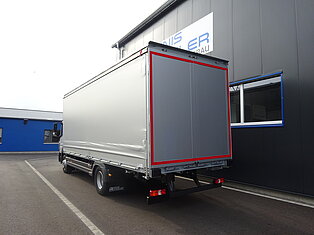 Ein LKW vor einem Lagerhaus geparkt.