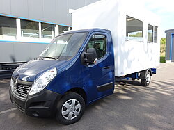 Ein blauer LKW mit einem großen weißen Aufbau.